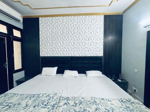 a bedroom with a large bed with two white pillows at Hotel Radha Madhavam Luxurious Boutique Stay in Mathura