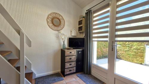 Cette chambre dispose d'une télévision et d'une commode avec une fenêtre. dans l'établissement Vaux sur Mer - côté PONTAILLAC - VILLA MITOYENNE - PISCINE COLLECTIVE, à Vaux-sur-Mer