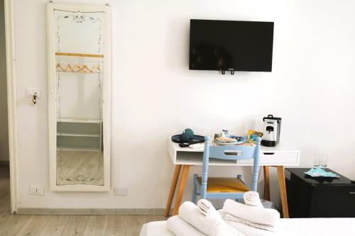 a room with a tv and a table and a mirror at Avia Room in Pachino