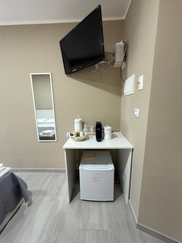 ein Raum mit einem Tisch und einem Fernseher an der Wand in der Unterkunft Reitano House in Catania