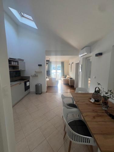a kitchen and living room with a table and chairs at Korcula Apartment direkt am Meer -Zrnovska banja -2,5 km zur Altstadt Korcula in Korčula