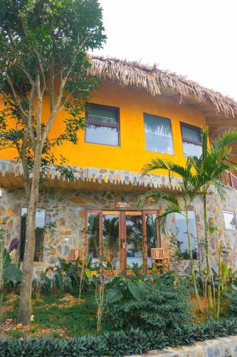an orange building with trees in front of it at Diều Sóc Sơn in Sóc Sơn