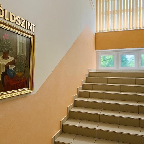 a staircase in a building with a painting and a window at Plaza Hotel Gyula in Gyula
