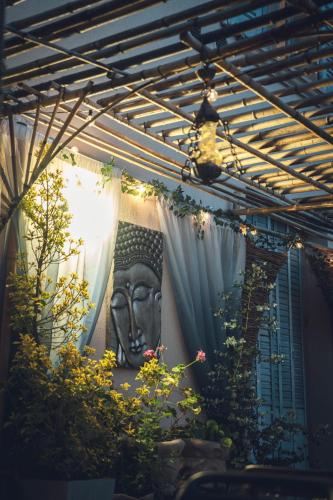 a statue of a head on a wall with plants at Logis Hôtel Vuillot in Cuiseaux