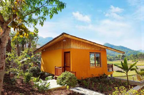 a small yellow house in the middle of a field at Diều Sóc Sơn in Sóc Sơn