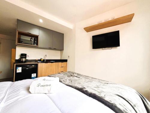 a bedroom with a bed and a tv on the wall at UniHome Niterói by Housi in Niterói