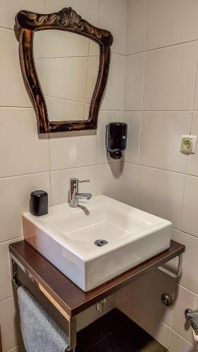 a bathroom with a white sink and a mirror at AL Vista Alegre in Horta