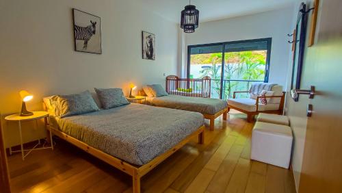Un dormitorio con una cama y un sofá y una ventana. en AL Vista Alegre, en Horta