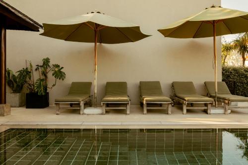 a group of chairs and umbrellas next to a pool at Galboka Residence in Nerezine