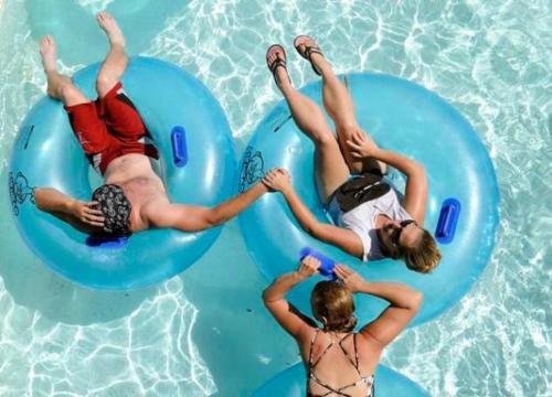 a group of people laying on infogie boards in a swimming pool at Plaza Hotel Gyula in Gyula