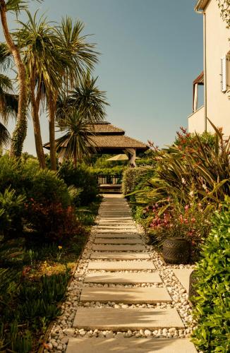 a stone path leading to a house with palm trees at Galboka Residence in Nerezine