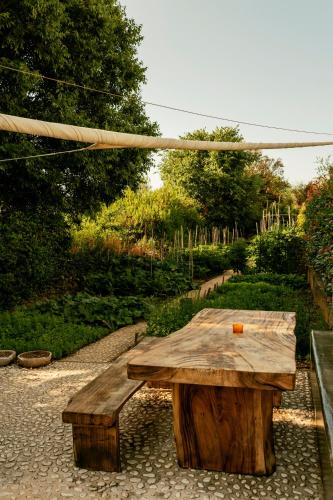 a wooden bench with a wooden table in a garden at Galboka Residence in Nerezine