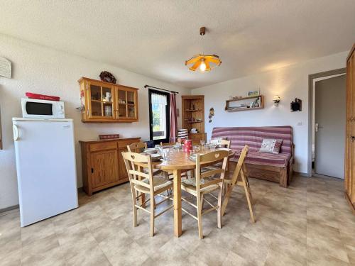 - une cuisine et une salle à manger avec une table et un canapé dans l'établissement Appartement 3 pièces avec balcon à Flumet, proche centre, navette ski gratuite, parking privé, 6 pers - FR-1-595-66, à Flumet
