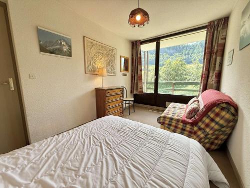 a bedroom with a bed and a chair and a window at Appartement 3 pièces à Flumet avec parking, 6 personnes - FR-1-595-66 in Flumet