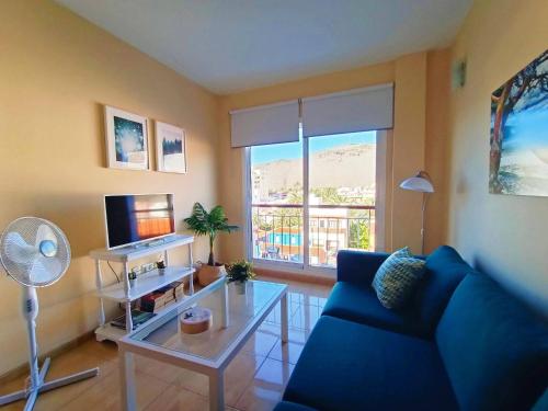 a living room with a blue couch and a tv at Miramar 5 - San Sebastin de La Gomera in San Sebastián de la Gomera