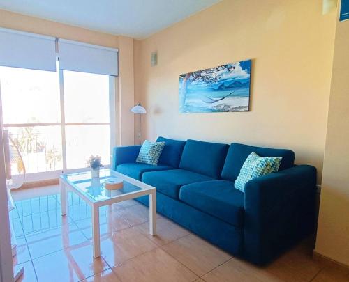 a blue couch in a living room with a table at Miramar 5 - San Sebastin de La Gomera in San Sebastián de la Gomera