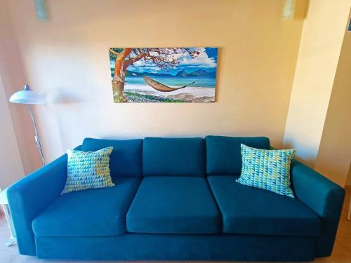 a blue couch in a living room with a painting on the wall at Miramar 5 - San Sebastin de La Gomera in San Sebastián de la Gomera