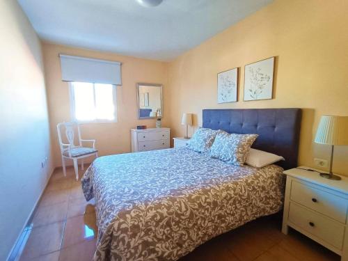 a bedroom with a blue bed and a chair at Miramar 5 - San Sebastin de La Gomera in San Sebastián de la Gomera