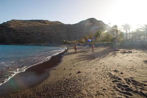 two people walking on a beach near the water at Miramar 5 - San Sebastin de La Gomera in San Sebastián de la Gomera