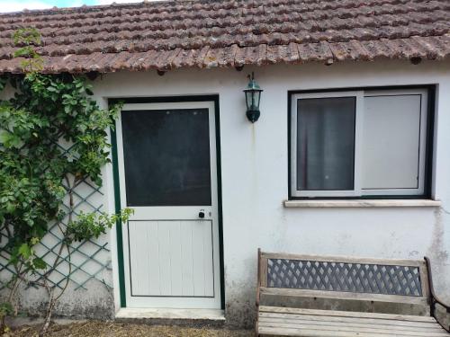 a white house with a door and a bench at Casinha da Lameira in Almagreira