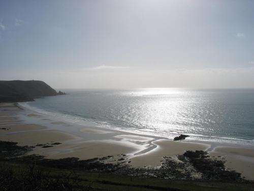 einen Strand mit der Sonne auf dem Wasser in der Unterkunft La Salicorne hébergement insolite in Saint-Germain-sur-Ay