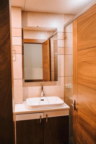 a bathroom with a sink and a mirror at Nigara Residency in Vandanmedu