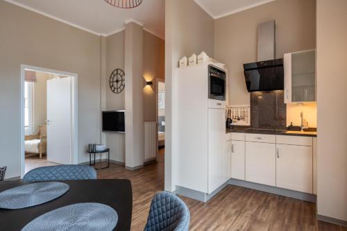 a kitchen and living room with a table and chairs at Rodehuus Wohnung 1 in Borkum