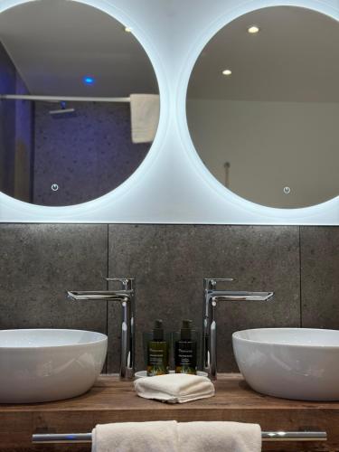 a bathroom with two sinks and a mirror at LA VILLA - by Hotel Remorino in Locarno