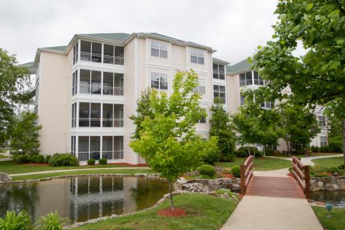 a building with a pond in front of it at The Suites at Fall Creek in Branson