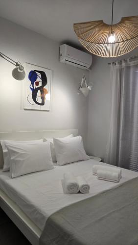 a white bed with two towels on top of it at Semeli Lux apt, Siviri in Siviri