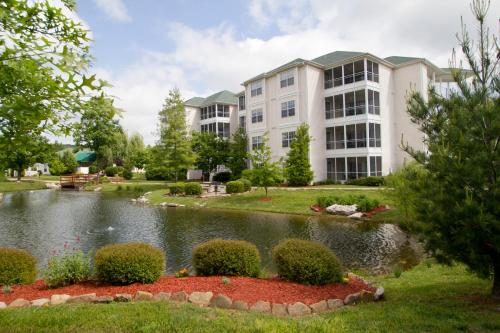 a building with a pond in front of a building at The Suites at Fall Creek in Branson