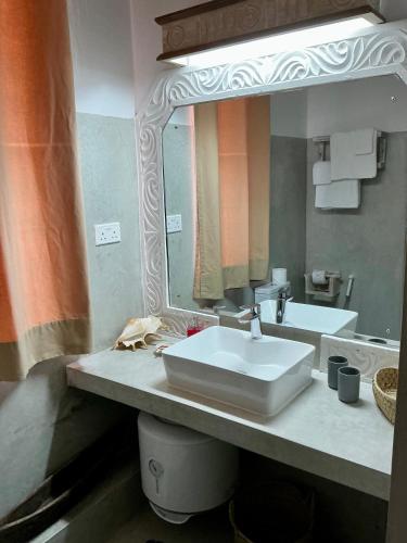 a bathroom with a sink and a large mirror at Luxury Penthouse 7 Islands View at Ocean Pearls in Watamu
