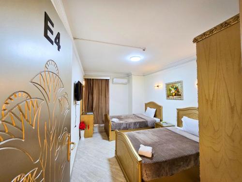 a hotel room with two beds and a tv at Afnan Cairo Airport in Cairo