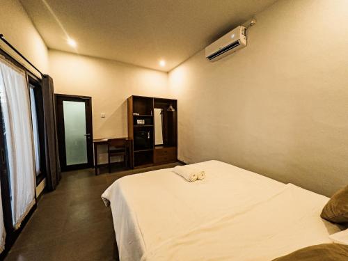 a bedroom with a bed with two towels on it at Kalamoana House in Gili Trawangan