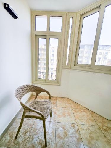 a chair in an empty room with windows at Afnan Cairo Airport in Cairo