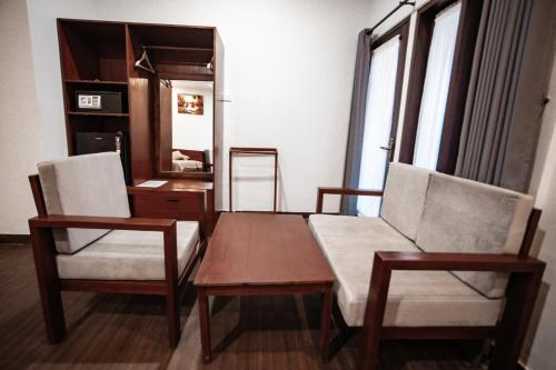 a room with two chairs and a table and a mirror at Kalamoana House in Gili Trawangan