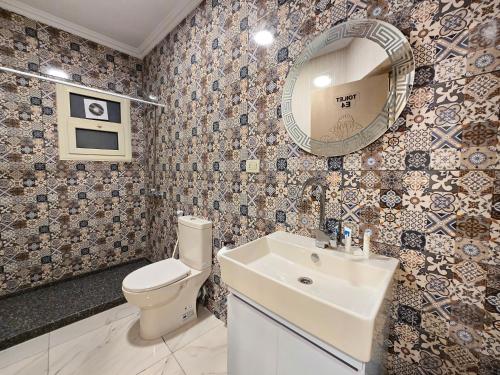 a bathroom with a toilet and a sink and a mirror at Afnan Cairo Airport in Cairo