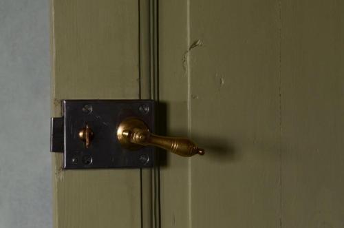 a brass doorhandle on a door with ajar at Stylish Swedish farmhouse in Borrby