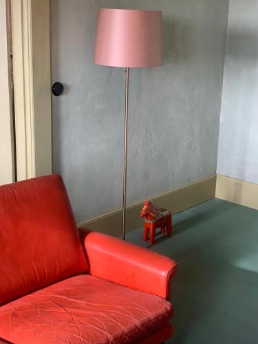 a red chair and a lamp in a room at Stylish Swedish farmhouse in Borrby