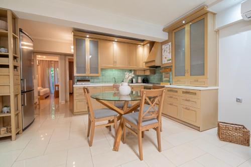 a kitchen with a table and chairs in a kitchen at Agnes by RentalsPro - Nea Moudania Halkidiki in Nea Moudania