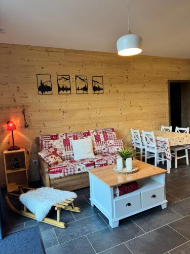 un salon avec un canapé et une table dans l'établissement Appartement à La Bresse - cadre naturel et calme, à La Bresse