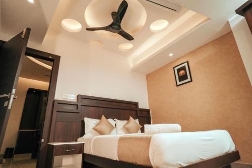 a bedroom with a bed with a ceiling fan at Nigara Residency in Vandanmedu