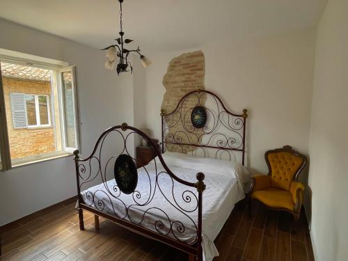 a bedroom with a bed and a chair at Casa Vacanze Bramante 78 in Urbino