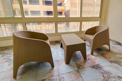two chairs and a table in front of a window at Afnan Cairo Airport in Cairo