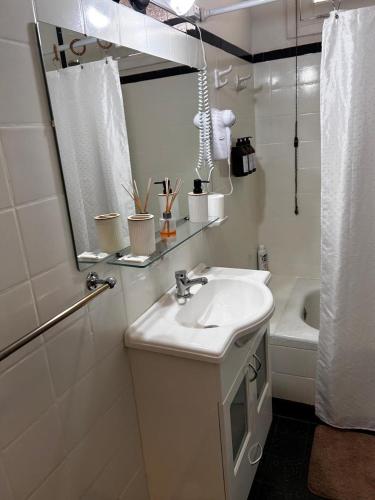 a bathroom with a sink and a mirror and a tub at La Casita de Salta 421 in Concordia