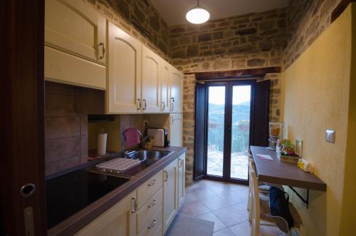 a kitchen with a sink, stove, and refrigerator at Dimore dell'Olmo - Ospitalità Diffusa in Castelmezzano