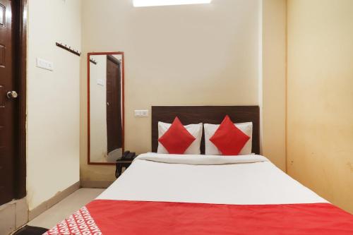 a bedroom with a large bed with red pillows at Hotel O Sai Pariwar in Vidya Nagar