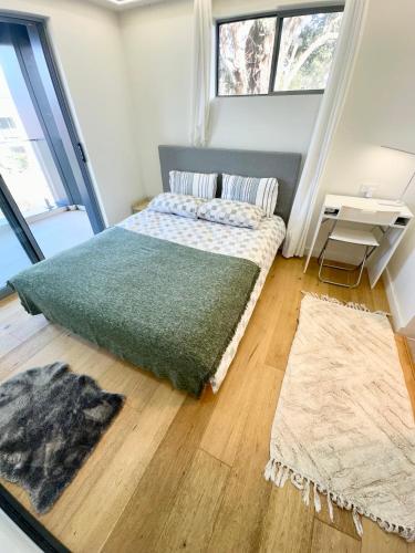 a bedroom with a bed with a green blanket at Cozy Room with Private Bathroom, Toilet and Balcony Close to Train Station and Airport in Revesby