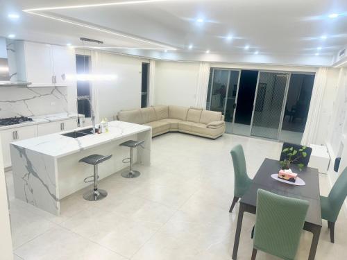 a kitchen and living room with a table and chairs at Cozy Room with Private Bathroom, Toilet and Balcony Close to Train Station and Airport in Revesby
