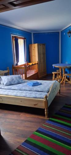 a bedroom with a large bed and a table at Стаи за гости Дончо Войвода in Koprivshtitsa